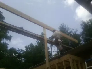 Carpenter setting a ridge beam over a new addition frame — Ice Dam Removal by Roofing Brothers in Lunenburg