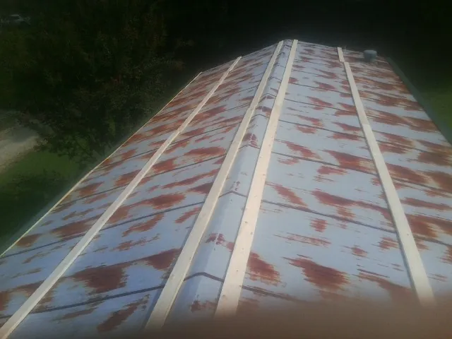 Rusted metal roof panels with new wood purlins before replacement — Storm Damage Roof Repair in Lunenburg by Roofing Brothers